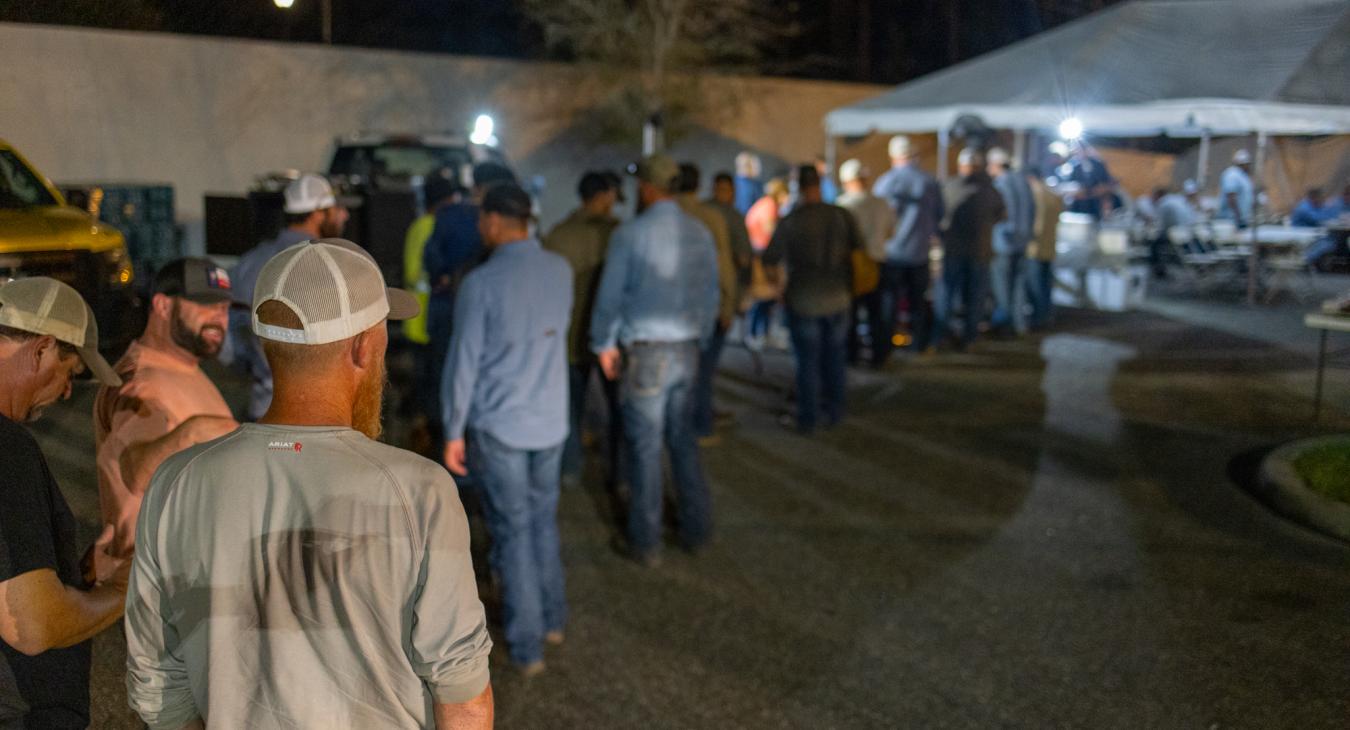 Lineworkers wait in line for food.